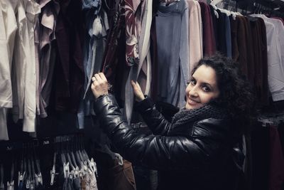 Portrait of smiling mature woman buying clothes in store