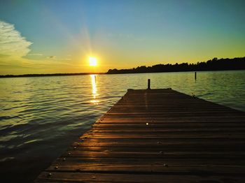 Pier on sea at sunset