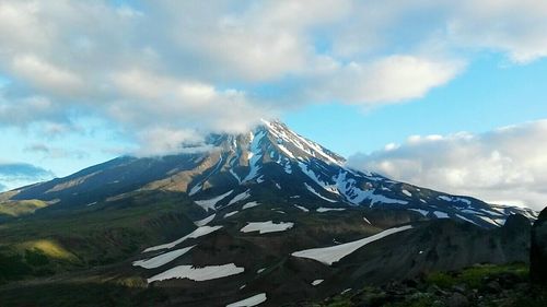 Scenic view of mountains against cloudy sky