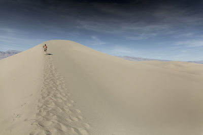 A man runs through the sand in death valley