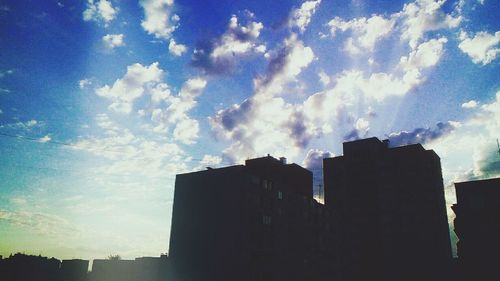 Low angle view of buildings against cloudy sky