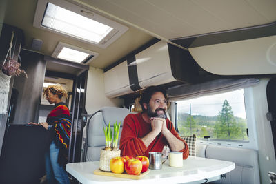 Happy mature man sitting in motor home