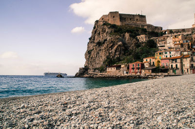 Scenic view of sea by buildings against sky