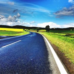 Empty road passing through field