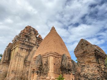 Low angle view of temple against cloudy sky