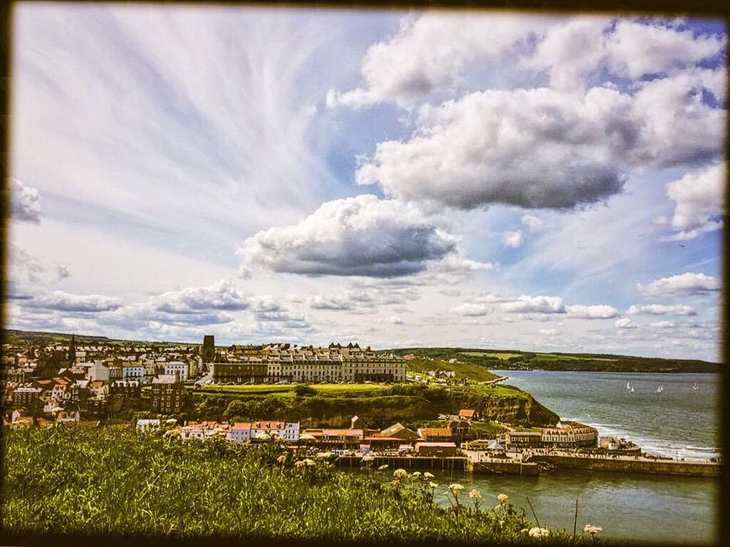 building exterior, sky, architecture, built structure, water, sea, cloud - sky, cloudy, cloud, residential structure, town, city, residential district, house, cityscape, horizon over water, high angle view, nature, residential building, townscape