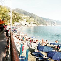 People on beach against clear sky