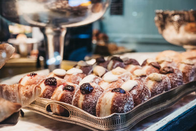 Close of up of a variety of jam doughnuts on a tray in a cafe window, view from outside.