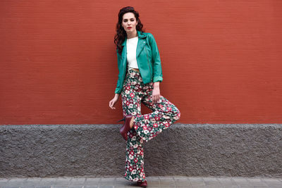 Portrait of woman standing against wall