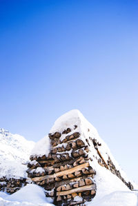 Scenic view of snow covered stack of logs
