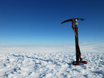 Ice pick stuck in snow on top of a mountain