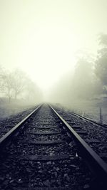 Railway tracks on landscape against sky