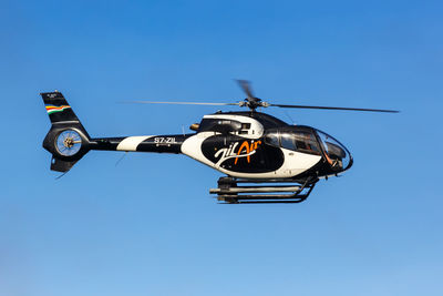 Low angle view of airplane against clear blue sky