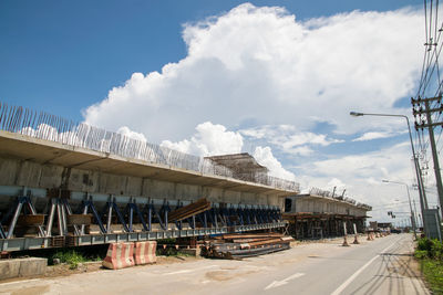 Road by built structure against sky