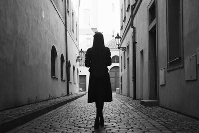 Woman standing on cobblestone street
