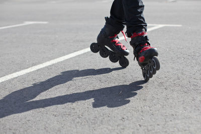 Low section of person roller skating on road