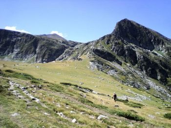 Mid distance of man walking on landscape against sky