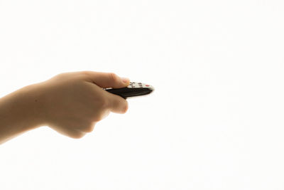 Close-up of hand holding camera over white background