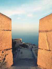 Built structure by sea against sky