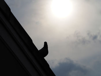 Low angle view of silhouette statue against sky