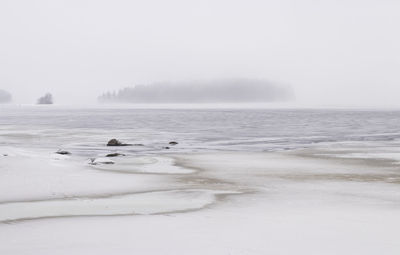 Scenic view of lake against sky during winter