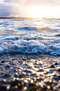 Surface level of waves rushing towards shore during sunset