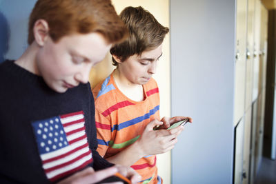 Schoolboys using mobile phones in locker room