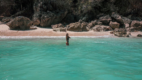 Aerial view of woman standing in sea