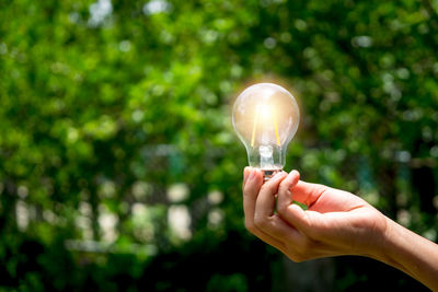 Close-up of hand holding light bulb