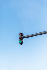 Low angle view of road signal against blue sky