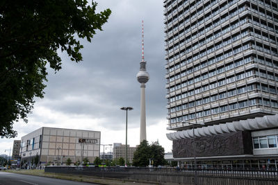 Buildings in city against cloudy sky