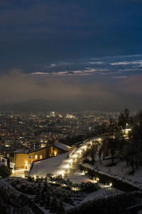 High angle view of illuminated city against sky at dusk