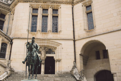 Low angle view of statue against building in city