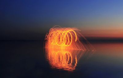 Light painting over sea against sky at night