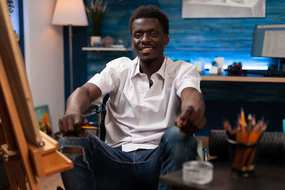 Portrait of young man sitting in workshop