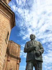 Low angle view of statue and building against sky