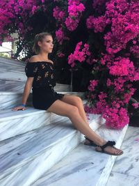 Beautiful woman looking away while sitting against plants