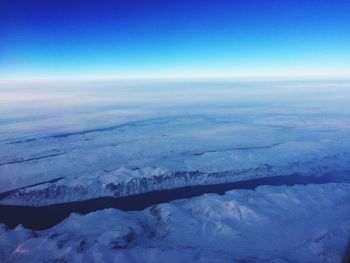 Aerial view of snow landscape against blue sky