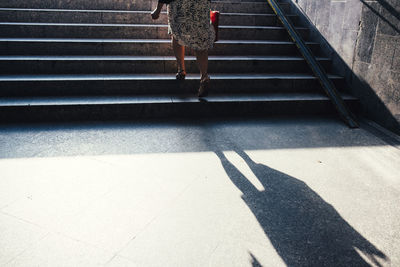 Low section of woman walking on staircase