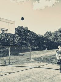 Man playing basketball court against sky