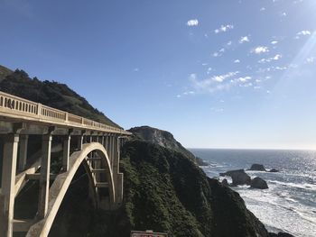 Arch bridge over sea against sky