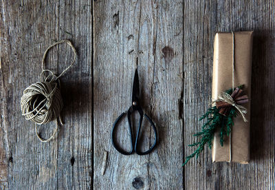 Directly above view of christmas present by scissors and string on table