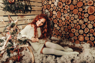 View of woman on snow covered log