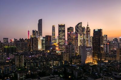 Aerial view of illuminated buildings in city against sky