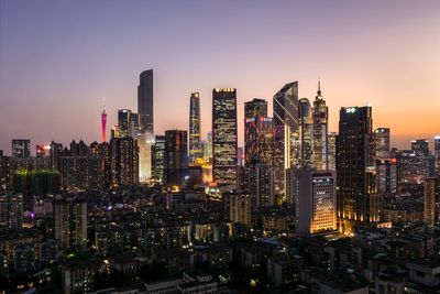 Aerial view of illuminated buildings in city against sky