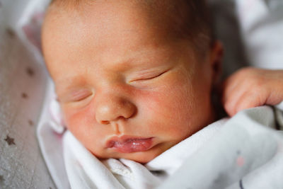 Newborn baby sleeps peacefully. gentle innocent baby, closeup portrait at home, top view