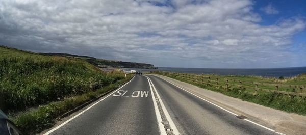 Road by landscape against sky
