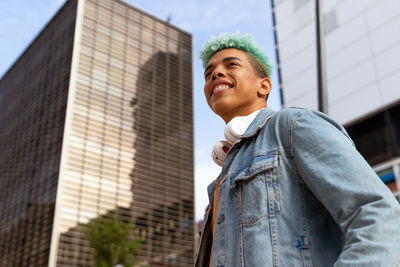 Portrait of smiling man standing against building in city