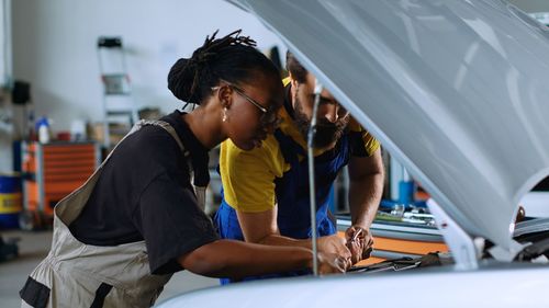 Side view of young woman holding car