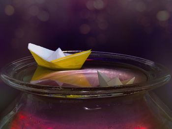 Close-up of paper boats floating on water in container